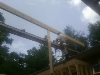 Carpenter setting a ridge beam over a new addition frame — Ice Dam Removal by Roofing Brothers in Yarnell