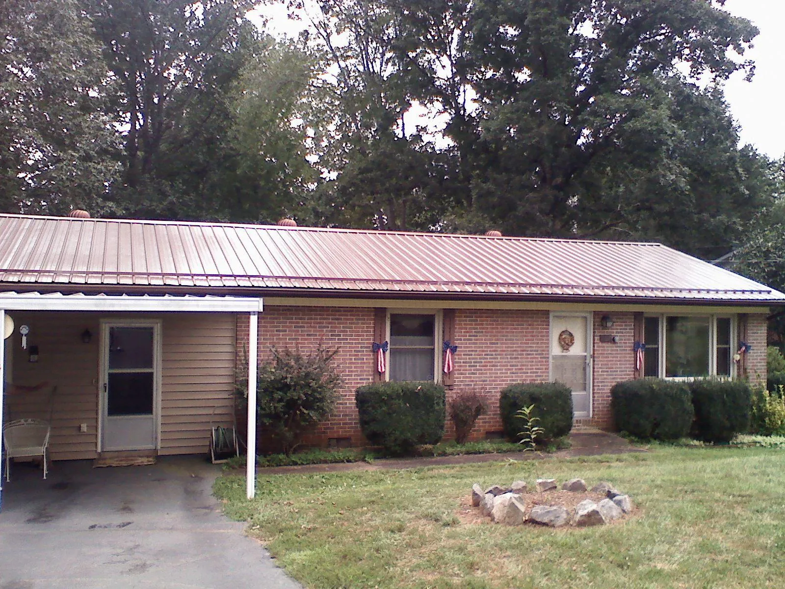 Bronze metal roof and carport on a brick ranch home — Roof Repair work by our crew in Yarnell